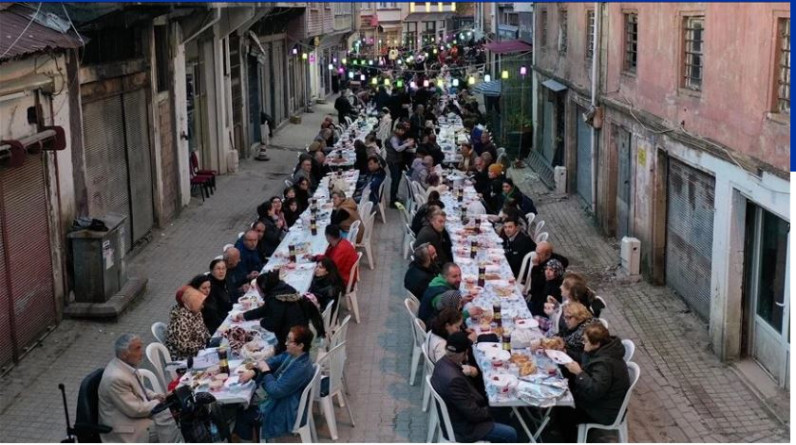 Mahalleli fazladan yaptığı yemekleri sokakta kurulan  iftar sofrasında paylaşıyor